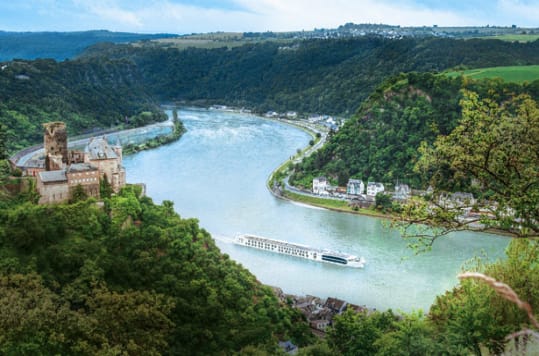 River Beatrice sailing on a European river surrounded y lush scenery and a small town